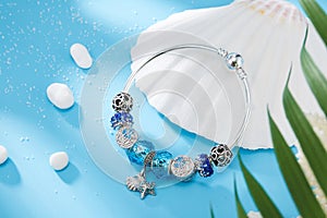Women`s platinum necklace and earrings with a diamond and blue precious sapphire stone on a silk blue background, close-up. Luxury