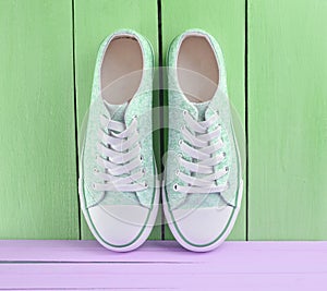 Women& x27;s retro hipster sneakers with white laces on a pink wooden