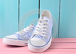 Women& x27;s retro hipster sneakers with white laces on a pink wooden floor against