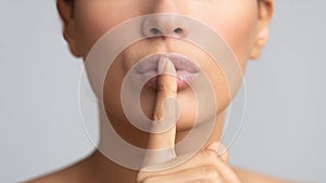 Women`s secret. Woman holding finger on lips