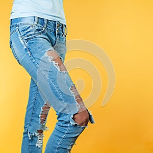 Women`s sexy legs in ripped jeans.