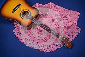 Women`s shawls and guitar on blue background