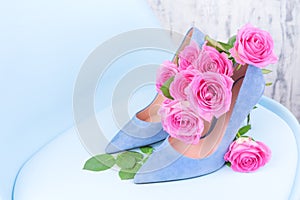 Women`s shoes blue high-heeled. Elegant shoes and a bouquet of roses in the interior. A gift for a girl in the feast of women.