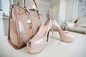 Women`s shoes cream colour high heels. Women`s shoulder bag in cream color.