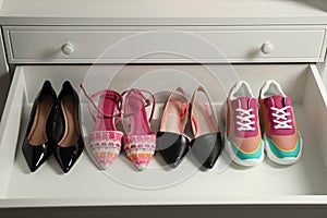 Women`s shoes in open drawer. Footwear storage