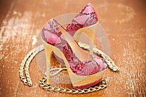 Women's shoes pink and gold chain. Stylized snake skin