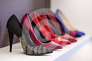 Women's shoes in the store. Shoes of different colors presented on the trading shelf