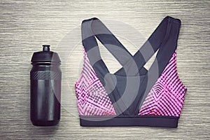 Women`s sports bra and Black Bicycle water bottle. Sport accessories and fashion.