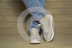 Women& x27;s sports comfortable shoes on concrete on the background of a brick wall