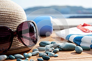 Women's straw sun hat, elegant sunglasses and beach equip on the balcony