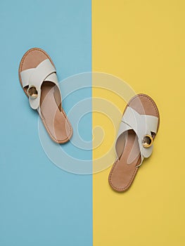 Women`s summer sandals on a light yellow and blue background