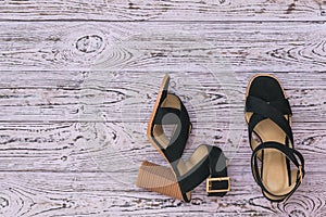 Women`s summer shoes of original design on a wooden background. Flat lay.