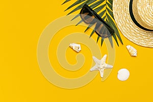 Women s summer straw hat, tropical palm leaves, monstera leaf, sunglasses, shells, starfish on yellow background top view flat lay