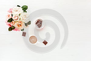 Women`s workspace with pink and beige roses flowers, accessories, diary on white background. Flat lay, top view trendy