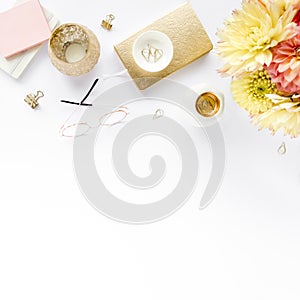 Women`s workspace with pink and beige roses flowers bouquet, accessories, diary, glasses on white background. Flat lay