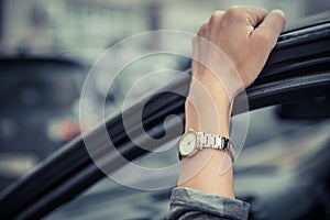 Women`s wristwatch on the girl`s hand. Girl in a hurry, standing in a traffic jam. Time is money. Man loses time