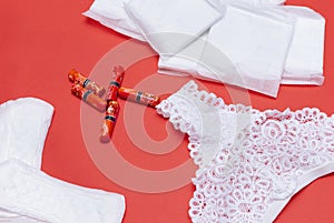 Women sanitary pads, daily pads, tampons, women`s white lace panties on on red background