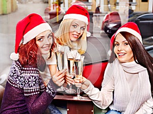 Women in santa hat drinking champagne.