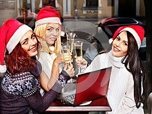 Women in santa hat drinking champagne.