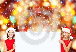 Women in santa helper hats with blank white board