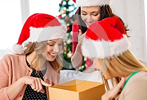 Women in santa helper hats with many gift boxes