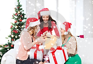 Women in santa helper hats with many gift boxes