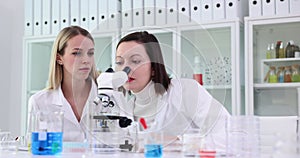 Women scientists observe specimen and react with surprise