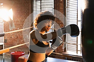 Women self defense girl power. African american woman fighter training punches on boxing ring. Healthy strong girl