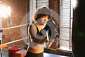 Women self defense girl power. African american woman fighter training punches on boxing ring. Healthy strong girl