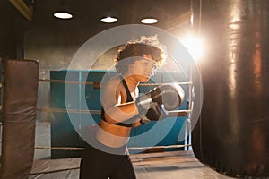 Women self defense girl power. African american woman fighter training punches on boxing ring. Healthy strong girl