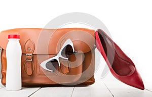 women set with leather bag, shoes, sunglasses and bottle of water isolated on white