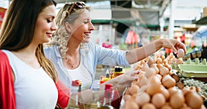 Women shopping fresh eggs at local farmer market