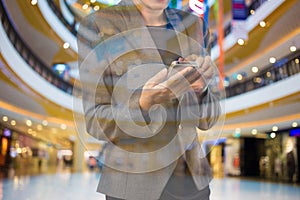 Women in shopping mall using mobile phone.