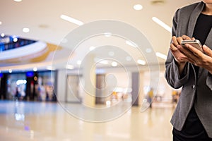 Women in shopping mall using mobile phone.