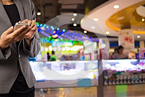 Women in shopping mall using mobile phone.