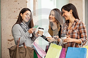 Women shopping and using their smartphones