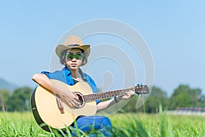 Women short hair wear hat and sunglasses sit playing guitar in g