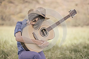 Women short hair wear hat and sunglasses sit playing guitar in g