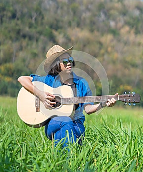 Women short hair wear hat and sunglasses sit playing guitar in g