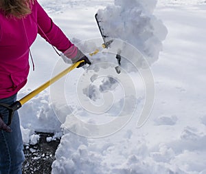 Women shoveling driveway after spring snow storm