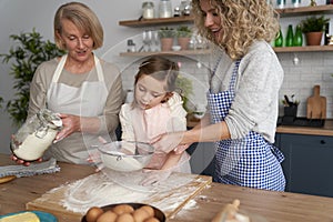 Smiling women sift the flour for Easter baking photo