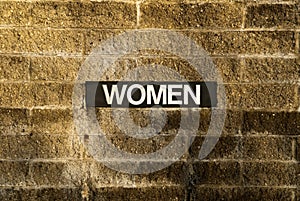 Women sign on brick wall