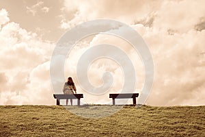 A women sitting alone on a bench waiting for love