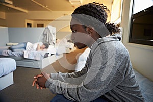 Women Sitting On Beds In Homeless Shelter