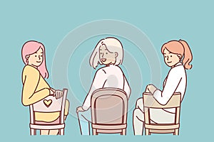 Women sitting on chairs with backs to screen turn around and look at you, during meeting