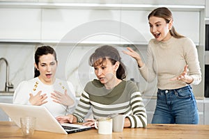 Women are sitting at computer and are immensely happy photo