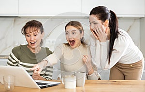 Women are sitting at computer and are immensely happy photo