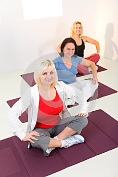 Women sitting cross-legged on mat