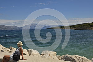 Women sitting on a pir looking out over the sea