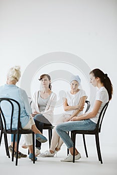 Women sitting together during psychotherapy with senior counselor